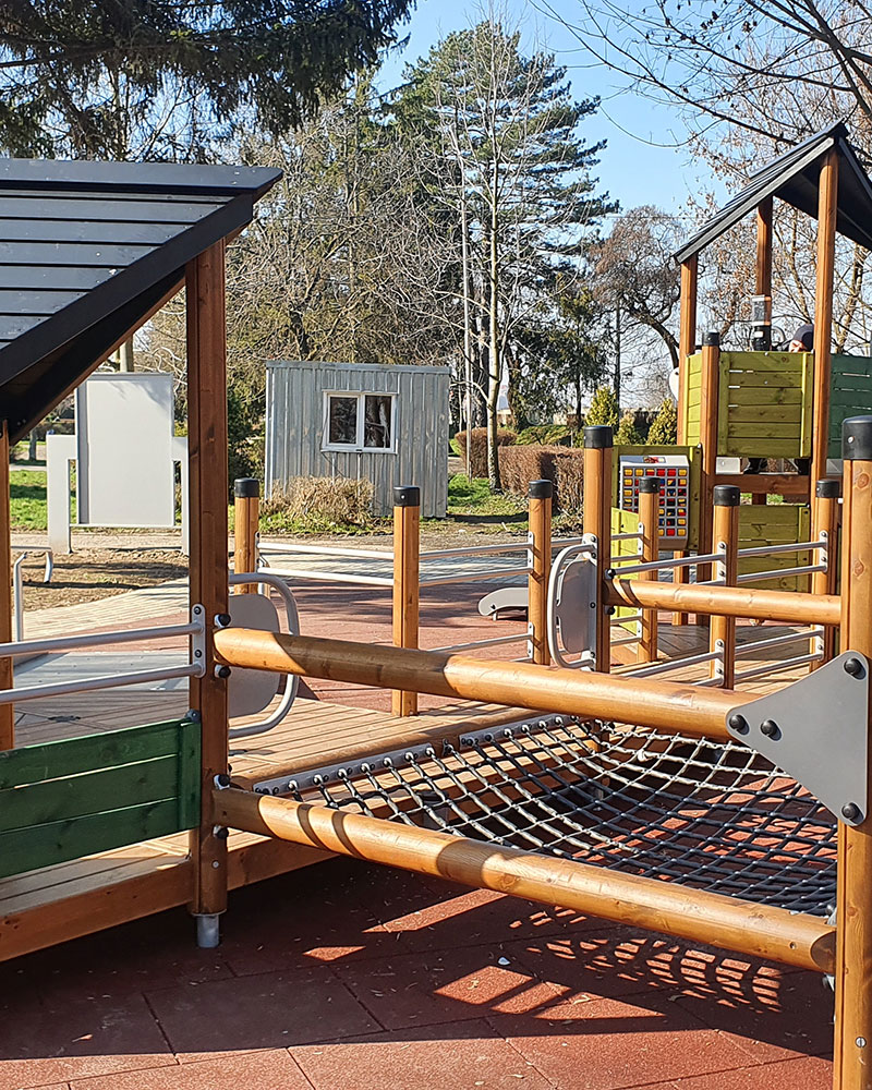 Wooden playground unit with net crawl area, where children either balance their way across, crawl acrossm, or use the area to take a rest.